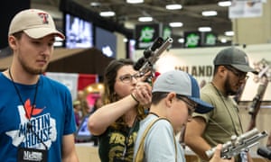 A family examine weapons at the NRA convention