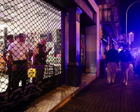 People look out from inside a shuttered store amid damage and disorder in Barcelona on Saturday.