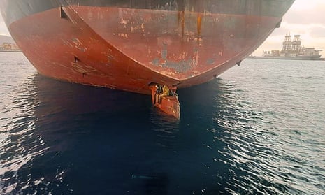 The three stowaways are shown perched on the rudder of the oil and chemical tanker Alithini II.