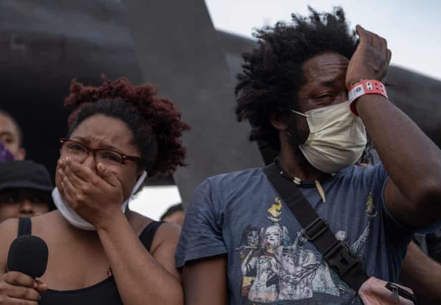Protester organizers shed tears while speaking during a peaceful march in Detroit