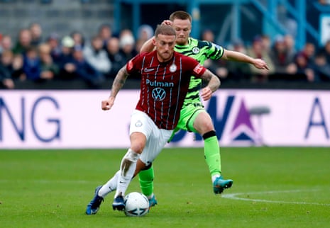 Louis Alessandra of South Shields (chestnut shirt) and Armani Little of Forest Green Rovers battle for the ball.