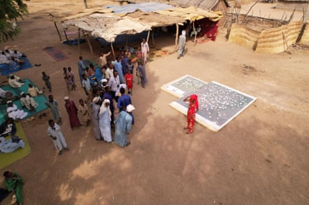 People standing outside next to a giant map of sustainable resources in the Mayo-Kebbi Est region of Chad