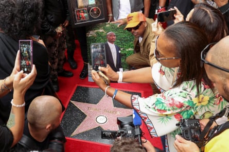 people crowd around the hollywood star and a photograph of Tupac Shakur