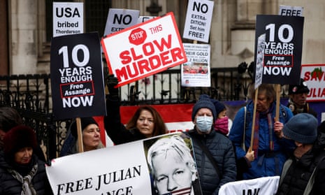 Supporters of Julian Assange protest outside the Royal Courts of Justice in London last month. signs say 'stop this slow murder' and '10 years is enough'