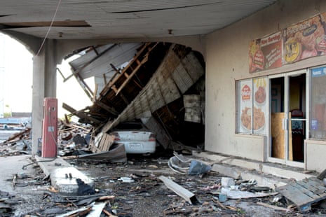A vehicle sits by a destroyed business as cleanup efforts continue Friday, in Perryton, Texas.