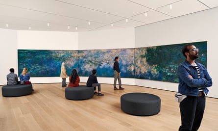 People stand around Claude Monet’s Water Lilies painting, extended and spread about a room