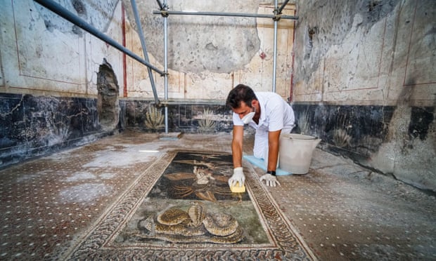 A worker cleans a mosaic at a nearby Casa di Orione, which will also be opening.