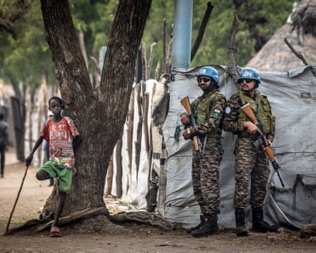 Indian peacekeepers serving with the United Nations Mission in South Sudan stand guard next to a young boy as they patrol outside local government offices in the strategic town of Akobo in Jonglei state in February.