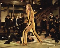 woman in yellow and black tracksuit holds sword