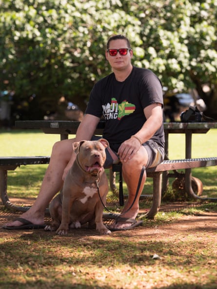 man sits on park bench with brown dog