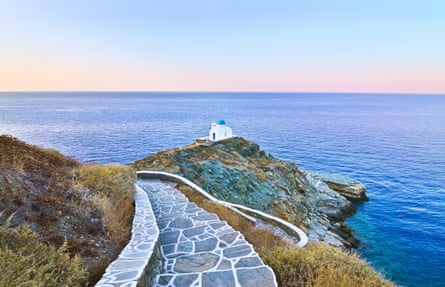 Classic blue and white Greek church on headland overlooking the sea