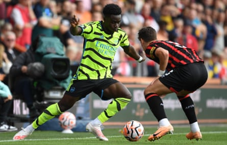 Bukayo Saka of Arsenal takes on Milos Kerkez of Bournemouth during a Premier League match.