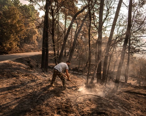 A man works to extinguish hot spots in an area burned by a wildfire near Casavieja, Ávila province, Spain.