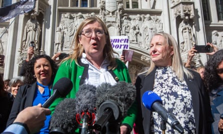 Susan Smith, a woman with brown hair and glasses wearing a green jacket, speaking in front of microphones outside the supreme court
