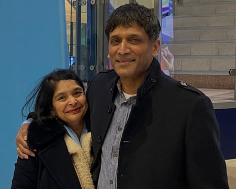 Bipin with his arm around Mala as they pose for a photo.
