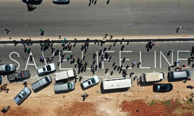 A human chain is formed by aid workers, medical and rescue services in a vigil calling for the Bab al-Hawa crossing to be kept open, near Bab al-Hawa, 2 July