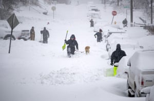 Neighbors work together in an effort to clear out as much snow as possible from East 8th Street Sunday in Duluth, Minnesota.