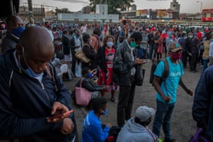 People wait in line for public transport to ferry them home after work.