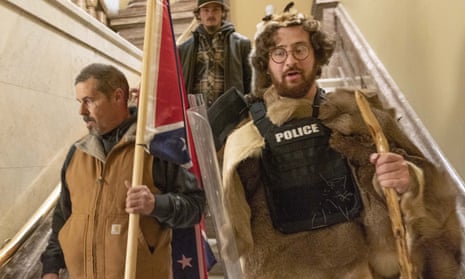 Aaron Mostofsky, right, seen inside the US Capitol wearing a police bulletproof vest and carrying a police shield, has been arrested on a felony count of theft of government property.