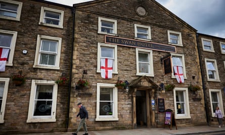 A person walks past a venue draped with England flags
