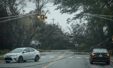 Vehicles turn around as trees and downed power lines block a road in Reserve Mines, Nova Scotia