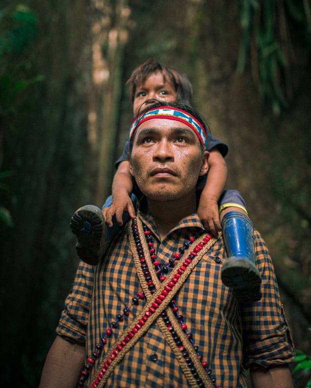 A member of the Achuar tribe with his child in the Amazon forest, Sharamenza, Ecuador.