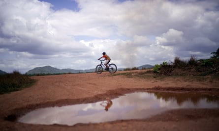 Um jovem anda de bicicleta por Wowetta, na região de Essequibo, na Guiana.