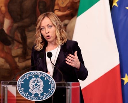 Giorgia Meloni gestures as she speaks at a podium