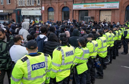 Police hold back Muslim protesters from marching along Belgrave Road in Leicester.