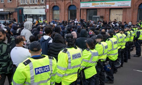 Police hold back Muslim protesters on Sunday in order to try to prevent clashes with the Hindu community.