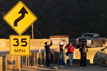 People take selfies at a bridge.
