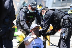 Police use a bolt cutter to remove locks around the necks of protesters in Melbourne