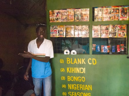 A DVD librarian offers a seat, in Kibera, Kenya.