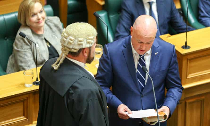 National MP Christopher Luxon takes his parliamentary oath while then National Party leader Judith Collins looks on.