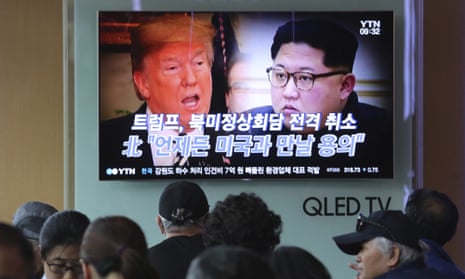 South Koreans watch a TV in Seoul showing Donald Trump and Kim Jong-un.