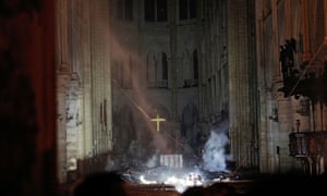 Smoke rises around the altar in front of the cross inside the cathedral