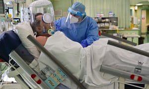 A member of the medical staff wearing personal protective equipment (PPE) tends to a patient in the Covid-19 unit of the Bolognini hospital in Seriate, Bergamo, on March 12, 2021.