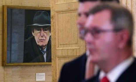 Sir Jeffrey Donaldson (right), the DUP leader, speaking to the media at Stormont today, with a picture of one of his predecessors, Ian Paisley, in the background.
