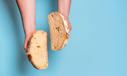 a loaf of bread chopped in half in a person’s hands
