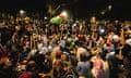 A throng of Pro-Palestinan protesters conduct a night-time sit-in with flags and lights