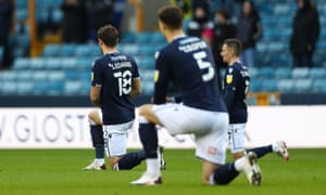 The Millwall players kneel before the match against Derby.