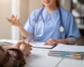 A doctor talking to a patient at a desk.