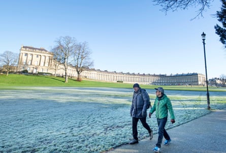 Two men walking on a clear frosty day with long regency building behind them
