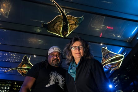 Artists Lynnette Griffiths and Jimmy John Thaiday stand beneath their collaborative installation Mermer Waiskeder: Stories of the Moving Tideat Sydney’s Exchange Square.