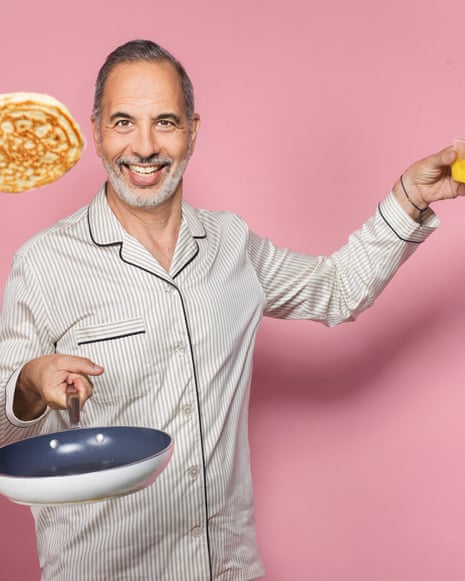 Yotam Ottolenghi smiles while tossing a pancake