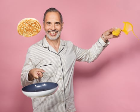 Yotam Ottolenghi smiles while tossing a pancake