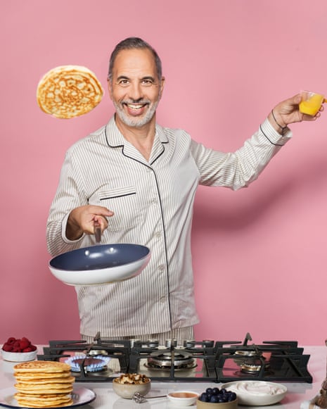 Yotam Ottolenghi smiles while tossing a pancake