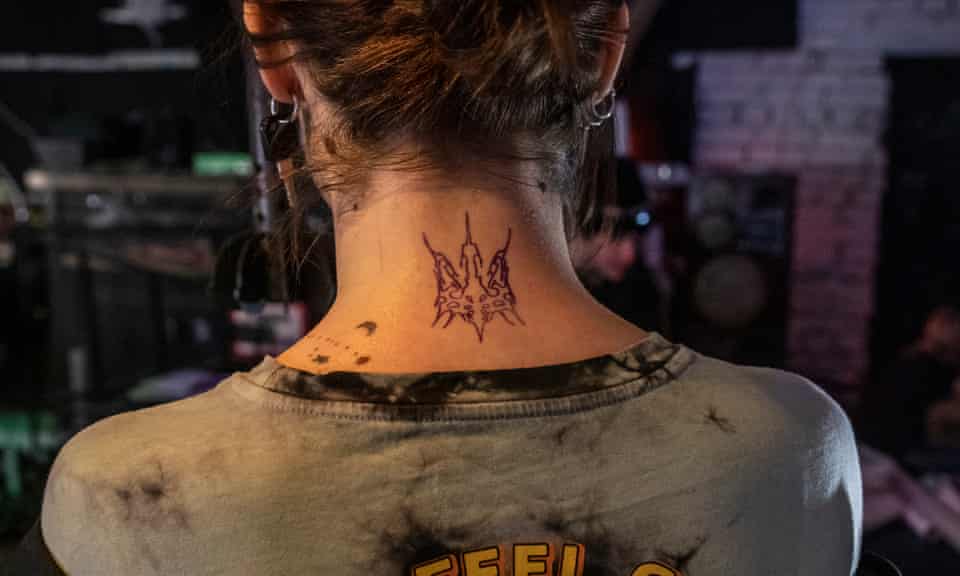 A stylised Ukrainian coat of arms tattooed on the neck of a woman in Kyiv.