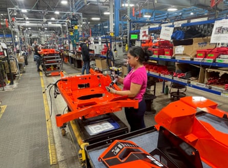 A worker installs parts at a power equipment assembly line