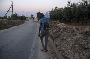 A man taking water back to the camp.